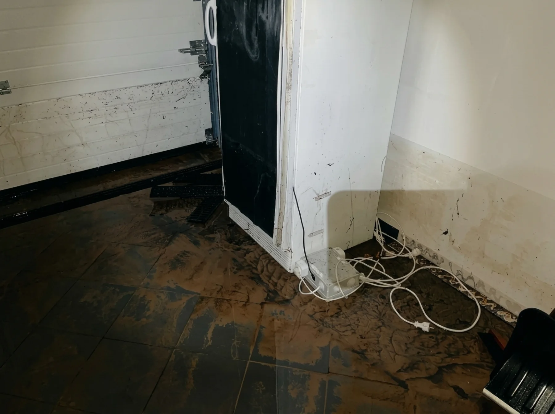 The curing chamber standing in muddy floodwater, a brown tide line up the wall.